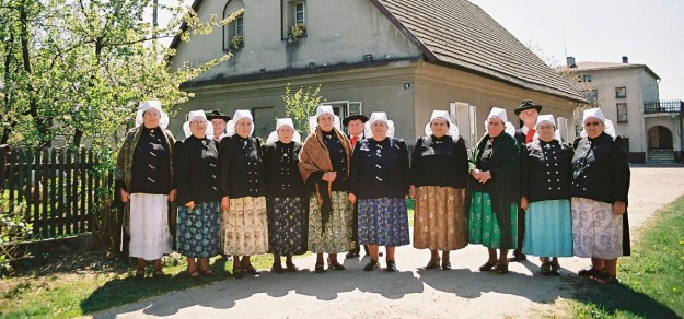 Członkowie zespołu przed najstarszym domem w Brzeźcach (fot. Brzeźczanie)